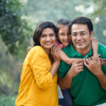 Father carrying daughter on shoulders at park
